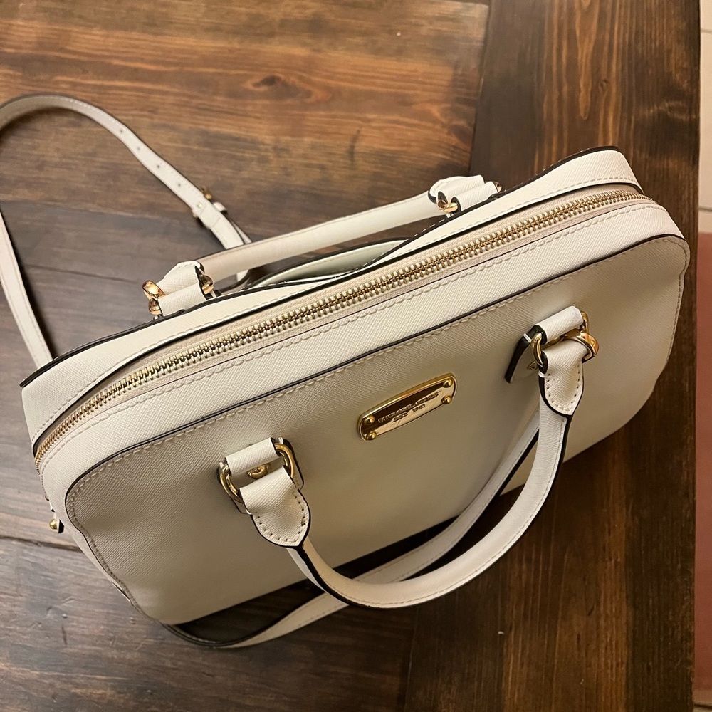 White Michael Kors saffiano leather handbag with gold and zipper hardware.